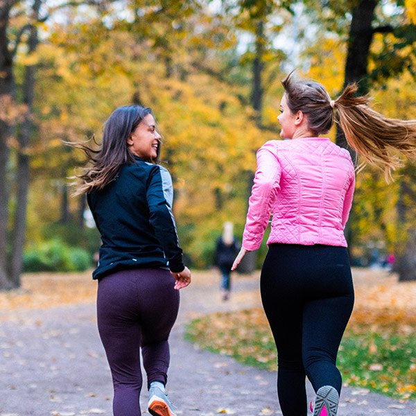 Two women on a run on a path through a park